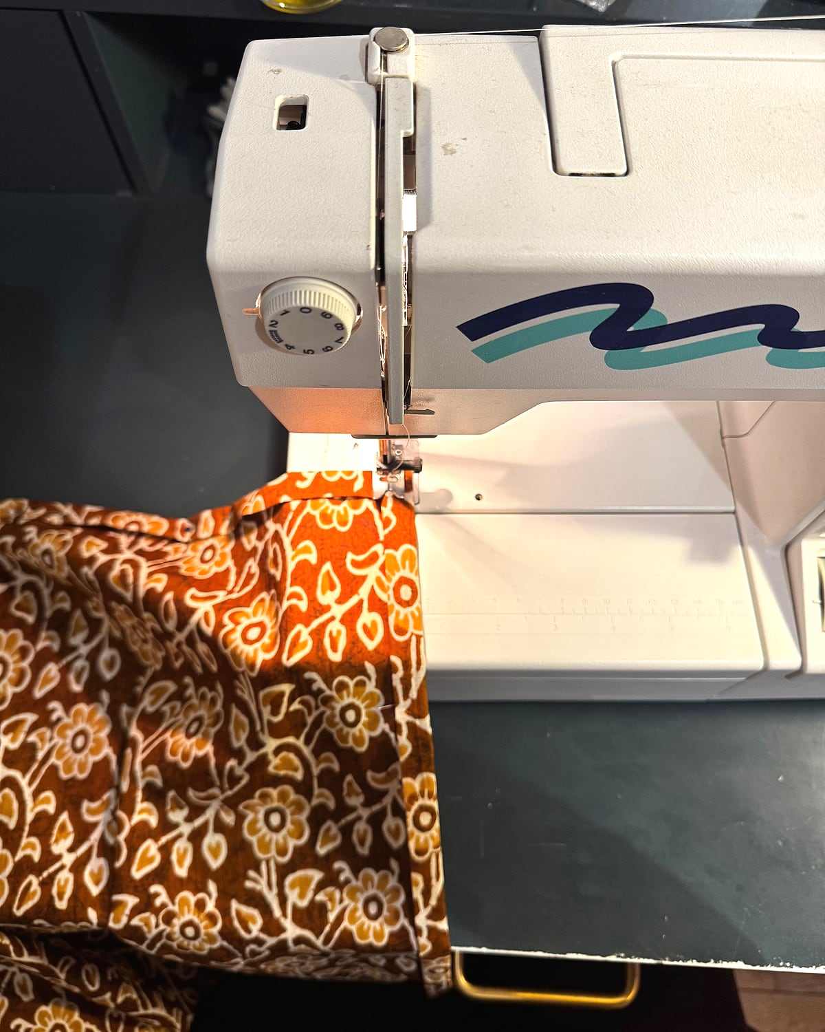 Coin d'atelier : machine, fils, ciseaux, coupons rangés